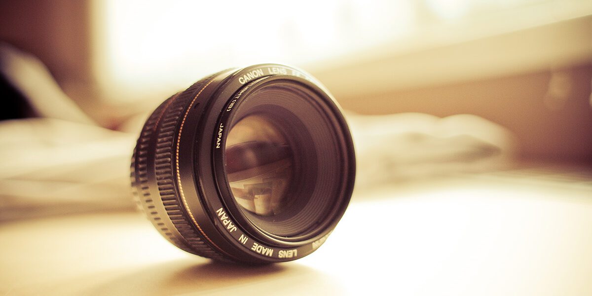 A close-up of a camera lens resting on a surface with soft lighting.