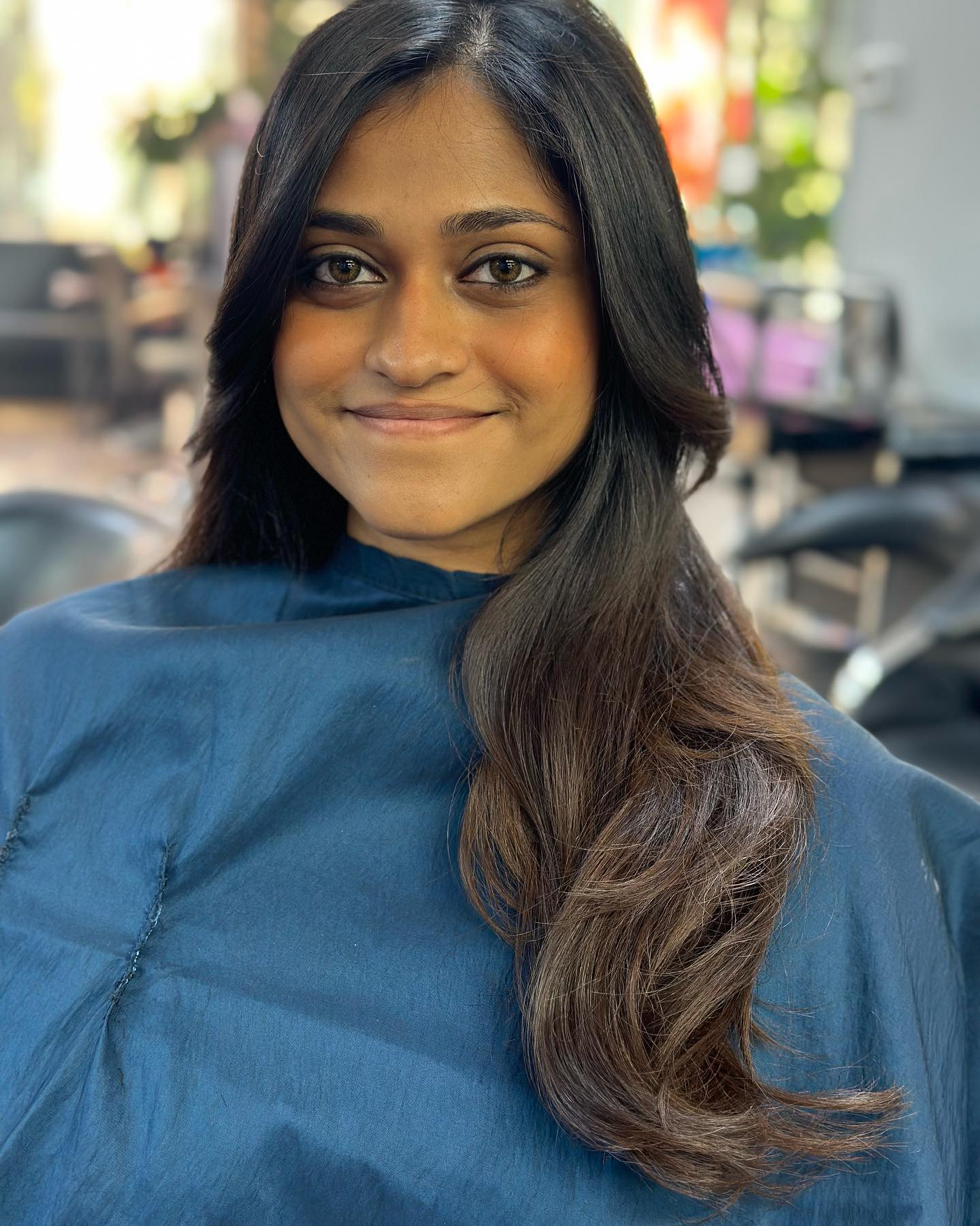 Long dark hair with face-framing layers.